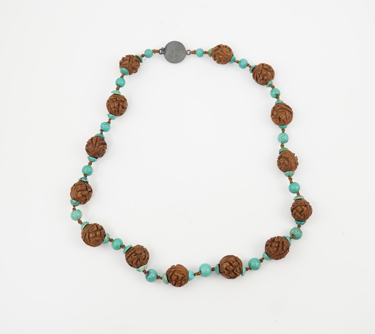 A Chinese silver filigree work and enamel scent bottle, by Wongshing, three carved peach stones, and a kernel and turquoise bead necklace, late 19/early 20th century